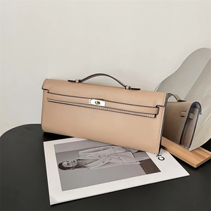 Detail of beige leather handbag featuring a metal lock and elegant black trim