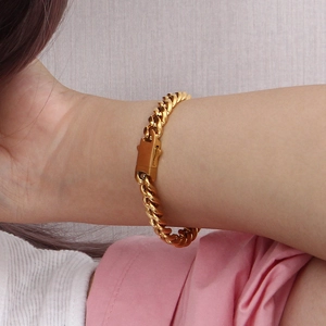 Detailed close-up of a gold Cuban chain bracelet with a secure fold-over clasp on a wrist