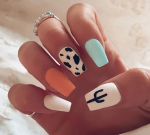 Close-up of long coffin fake nails with blue, orange, and cow print patterns worn on hand