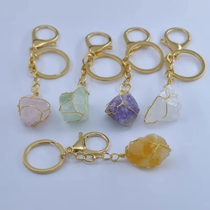 Détail de porte-clés artisanaux en fil doré avec diverses pierres naturelles brutes