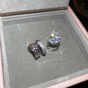 Détail macro de bagues d'oreilles argentées en zircon sur support en velours