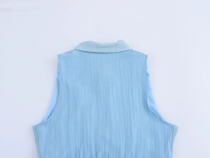 Macro shot of light blue sleeveless shirt dress featuring vertical pleated texture and collar