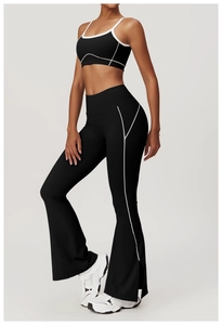 Side view of black yoga set with white trim, high waist flared leggings and sports bra