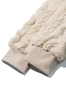Detailed close-up of beige plush hoodie cuffs showing soft fleece texture and knit stitching