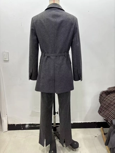 Vue arrière du blazer gris foncé ceinturé et du pantalon avec fente latérale sur mannequin