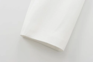 Close-up of white woven fabric cuff texture with precise stitching for short jacket