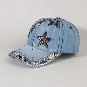 Detail of silver rhinestones and black star patch on blue washed denim baseball cap
