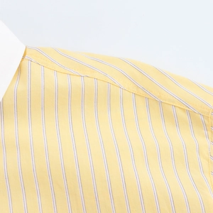 Close-up detail of yellow and white striped cotton shirt collar and shoulder stitching