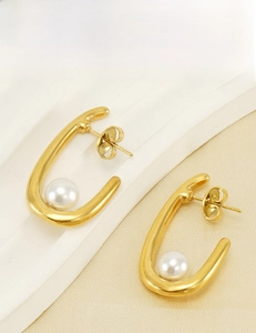 Détail de boucles d'oreilles perles en U dorées avec placage 18K et texture lisse