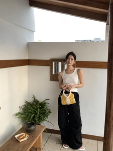 Detail of yellow and white hand-woven tote bag with diamond pattern for casual style
