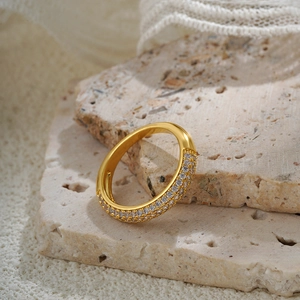 Minimalist 18k gold vintage ring with pavé-set zircons on a textured stone background