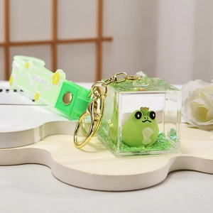 Detail of green frog keychain with liquid glitter oil and silicone wrist strap