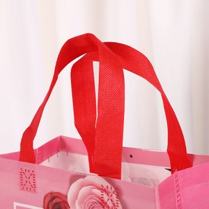 Detail of pink Mother's Day gift bag showing red handle and rose floral print