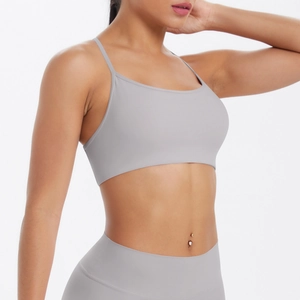 Détail des fines bretelles croisées d'un soutien-gorge de yoga gris respirant à dos ouvert