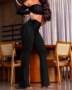 Detail of high waisted black flare jeans with elastic waistband on a female model