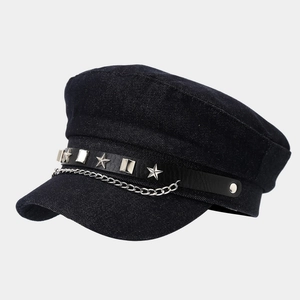 Detail of navy flat-top cap featuring denim texture with silver stars and chain decoration