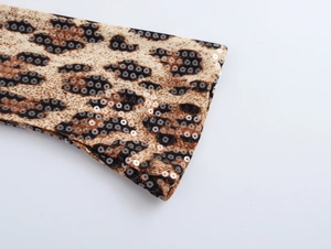 Vue détaillée du tissu imprimé léopard avec des paillettes brillantes pour une robe de fête