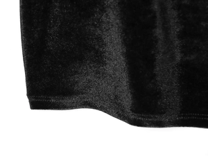 Gros plan de l'ourlet d'une robe en velours noir montrant les coutures et la texture du tissu