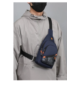 Detail of navy blue chest bag featuring orange zipper pulls and a camouflage pattern pocket