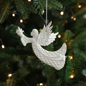 White angel wing Christmas ornament with silver glitter hanging on a festive tree branch