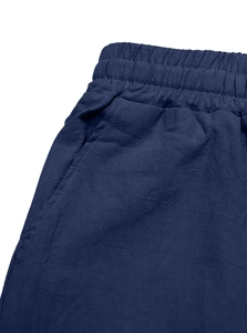 Close-up of navy blue linen trousers with elastic waistband and side pocket detail