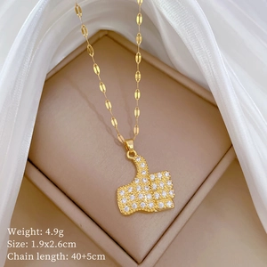 Detailed view of a gold thumb gesture pendant necklace with sparkling zircons in a box