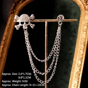 Silver skull brooch with triple chain tassels and rhinestones on a display stand