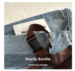 Detail of a sturdy black buckle and brown woven nylon strap on a stylish waist bag