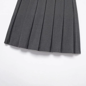 Close-up of dark grey pleated culottes in woven fabric with elegant fold details