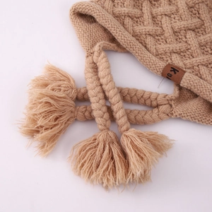 Winter knit baby bonnet with thick diamond pattern, braided straps and warm earflaps