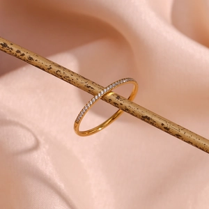 Detailed close-up of 18K gold plated ring with micro-pave zircons on silk background