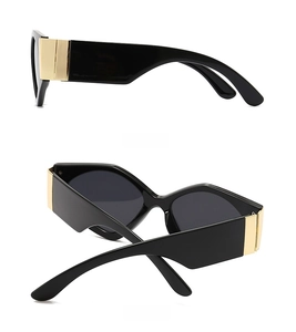 Detail view of oversized geometric sunglasses with wide gold metal side accents