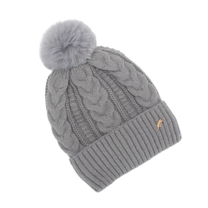 Détail du bonnet en maille torsadée grise avec pompon en fourrure et décor feuille