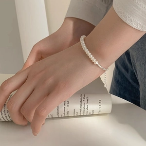 Elegant S925 sterling silver freshwater pearl bracelet on wrist with book background