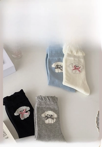 Detail of knit socks with cute dog embroidery, bows and ruffled edges in four colors