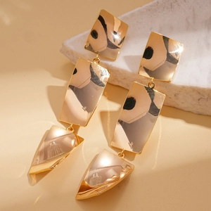 Macro shot of 18k gold plated geometric earrings with twisted square design and mirror finish