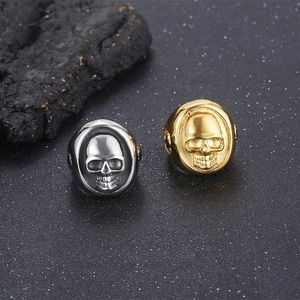 Punk style stainless steel skull rings for men in silver and gold finishes shown at 45-degree angle