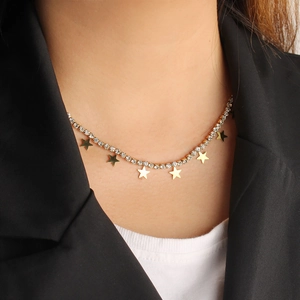 Detail of elegant gold star necklace with shimmering rhinestones worn by a model