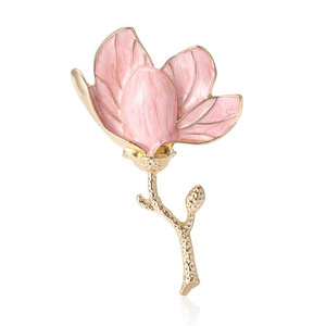 Pink enamel magnolia flower brooch with gold plating on a reflective white background