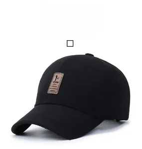 Close-up of black wool baseball cap featuring a square brown leather patch with text