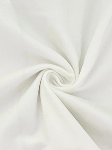 Detail of white soft tiered cake skirt fabric showing smooth cotton knit texture