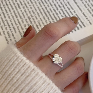 Detail shot of a silver heart-shaped smiley face ring on a dual twisted rope band
