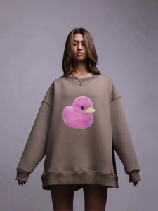 Nahaufnahme des süßen Entenprints auf warmbraunem Oversized-Baumwoll-Sweatshirt