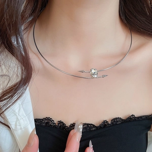 Detailed view of silver choker featuring oval gemstone and arrow design on female model