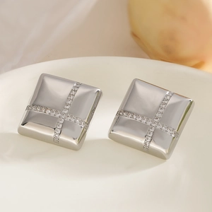 Square silver-plated stud earrings with cross-set zircons on a white ceramic tray