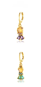 Detail display of fishtail earrings featuring purple and blue cubic zirconia in gold