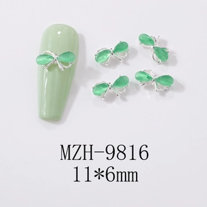 Detail showing 11x6mm green cat-eye stone butterfly nail charm with silver metal base