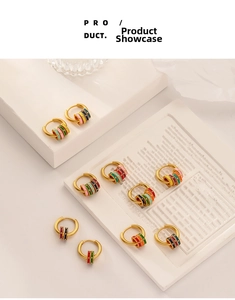 Detail of vintage matte gold hoop earrings with multi-colored enamel ring charms