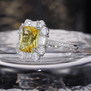 Macro shot of luxury ring with radiant yellow gemstone and pavé diamonds on silver band
