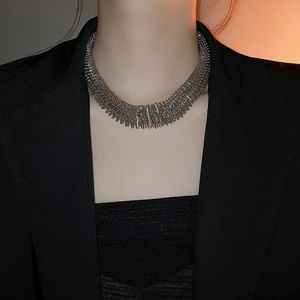 Close-up of a chunky silver woven spring mesh necklace styled on a fashion model